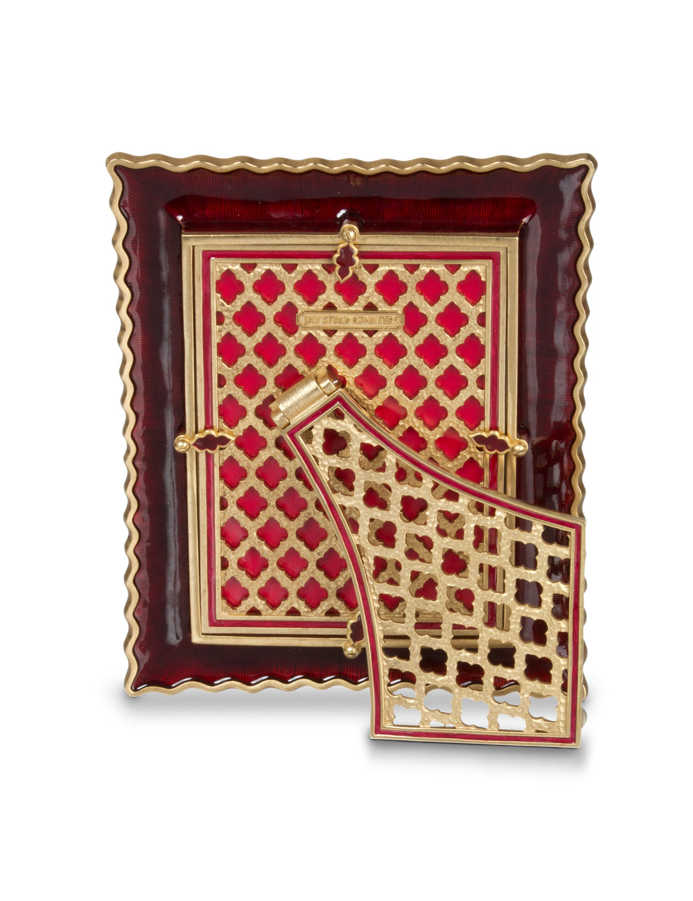 5" x 7" The back of this stunning Jay Strongwater picture frame features a rich ruby-red enamel finish complemented by intricate gold-tone latticework and elegant quatrefoil patterns. Delicate gold accents, scalloped edges, and the signature Jay Strongwater nameplate showcase the exceptional attention to detail. A beautifully designed hinged easel stand completes this luxurious piece, allowing it to be elegantly displayed on a tabletop, mantel, or shelf.