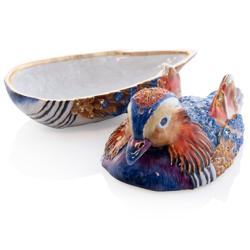 Tanner Mandarin Duck Box. This duck features orange, blue, purple, and yellow enamels. Adorned with gold and blue crystals. View of lid off, showing white enamel on inside.
