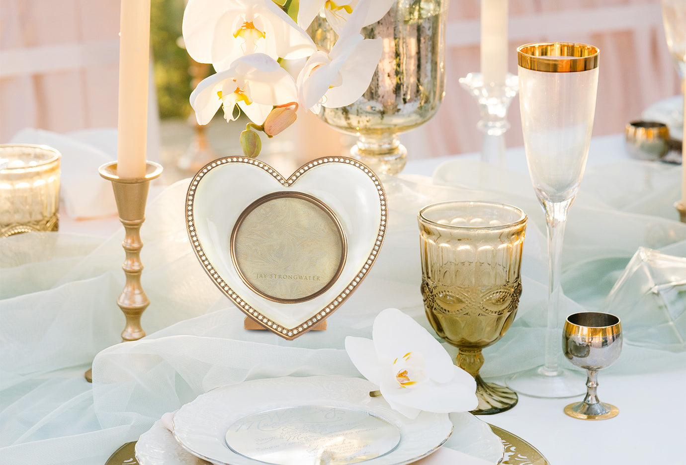 A tablescape at a wedding featuring a heart shaped Jay Strongwater picture frame
