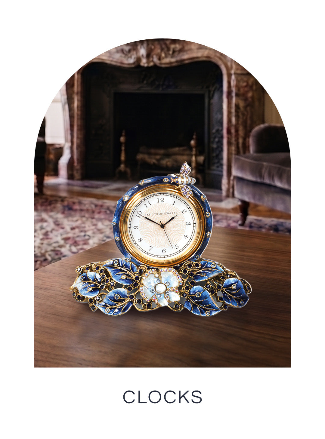 Ornate Jay Strongwater desk clock featuring blue enameled leaves, a central floral accent, and a jeweled bee perched on top, displayed for the Clocks collection.